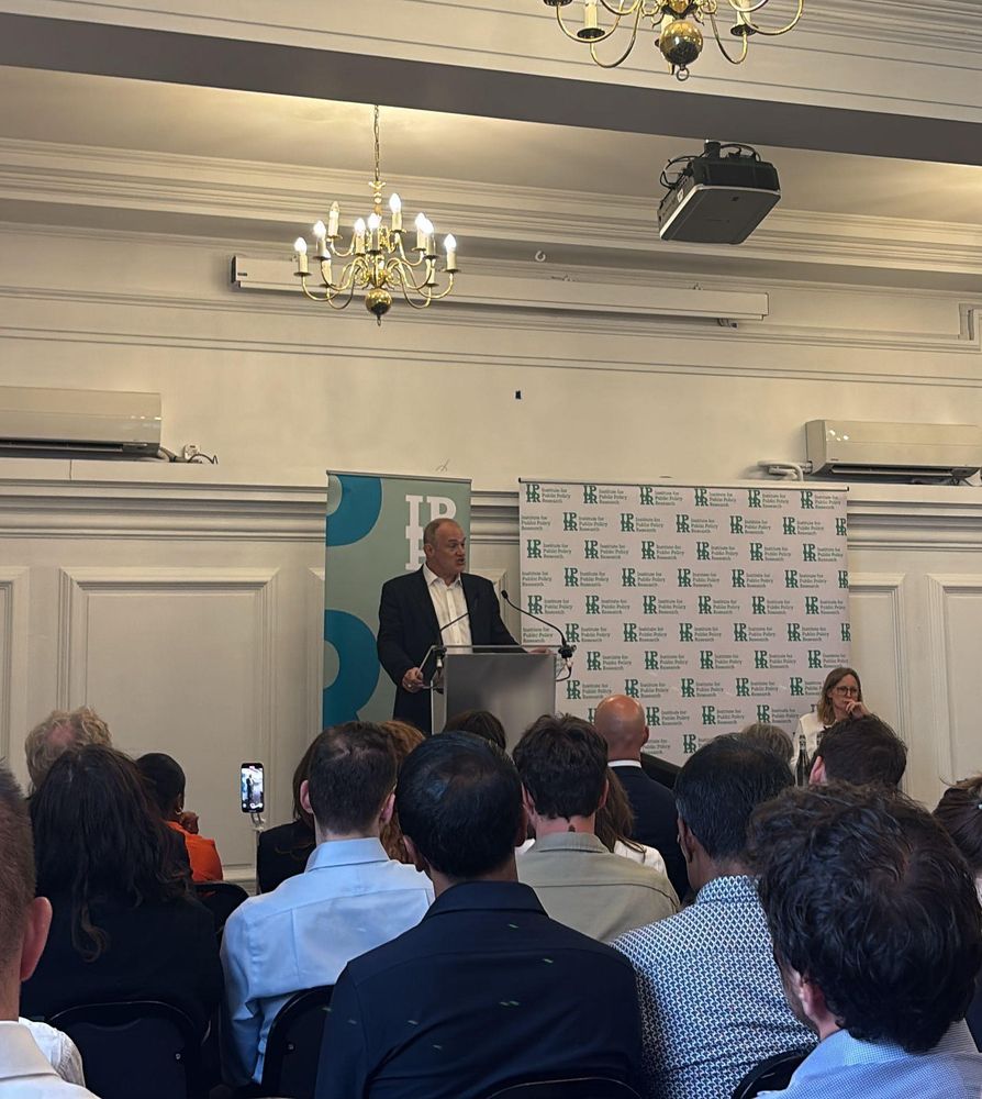 Ed Davey speaking from a lectern with an IPPR banner behind him