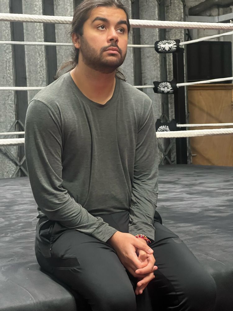 Man sits alone on a wrestling ring
