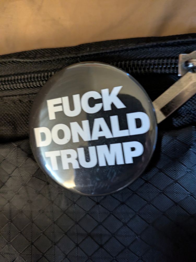 Round black button with "FUCK DONALD TRUMP" in white and all caps