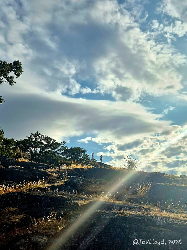 Photograph taken by Jennifer Lloyd of two people walking on a sunny hill