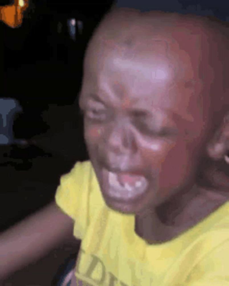 a close up of a child 's face with a yellow shirt on .