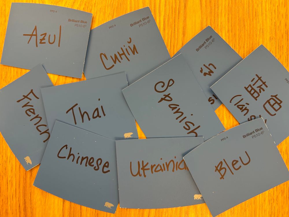 Blue paint chips either word blue written in Spanish, French, Thai, Chinese and Ukrainian