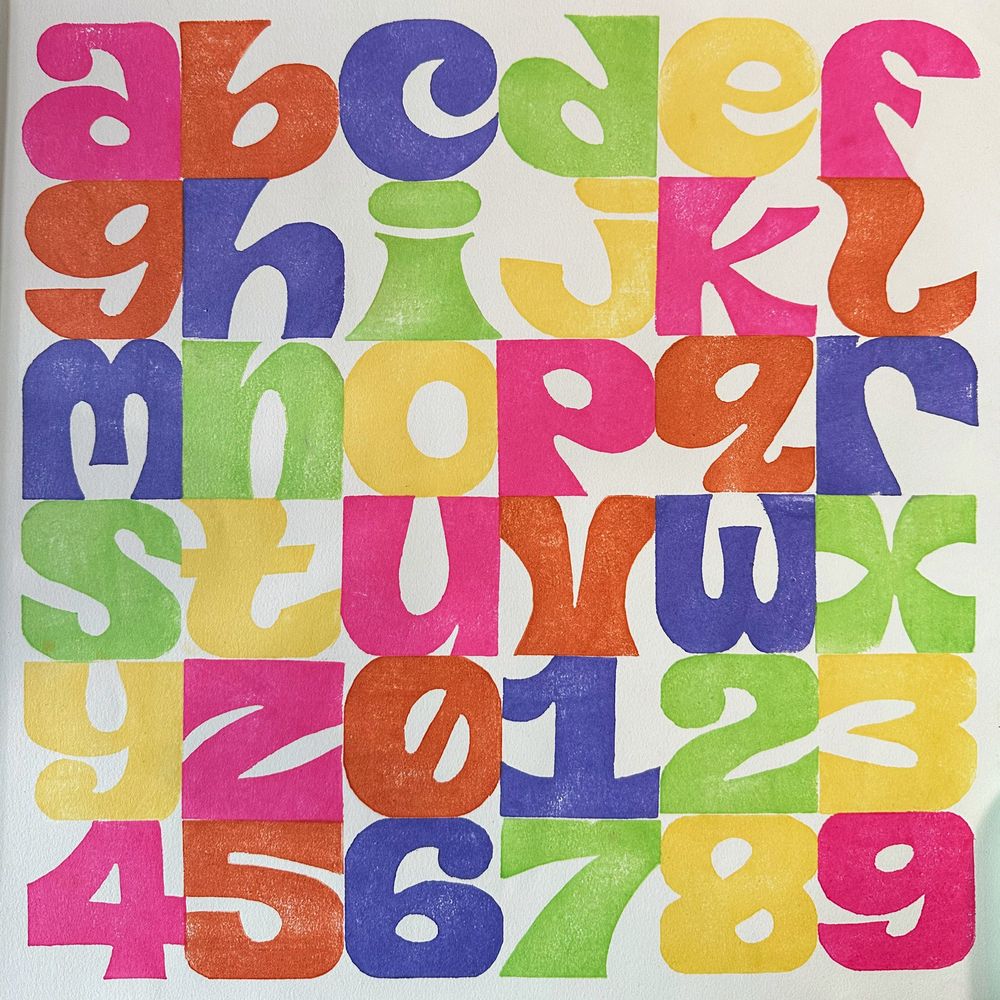 36 hand-drawn, hand-carved characters printed together. Ranger ink on drawing paper. Each letter is 2x2 inches and bright colors