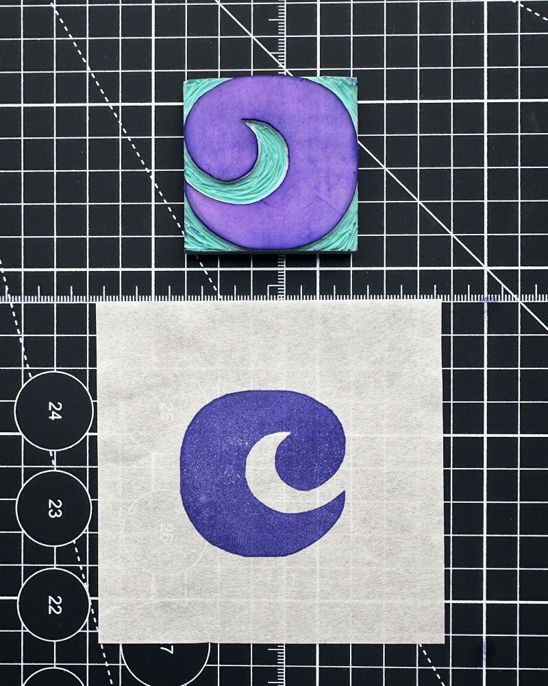 Photo: 2x2 inch purple letter c carved in faux linoleum and stamped on a square of paper in purple.