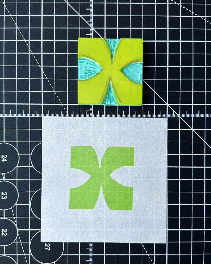 Custom lettered X linocut and stamped onto white paper in bright green