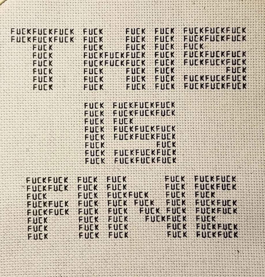 the words 
THIS
IS
FINE
made out of much tinier letters spelling "FUCK" over and over.
this is all done in black thread on cream aida cloth, so someone stitched this by hand.
