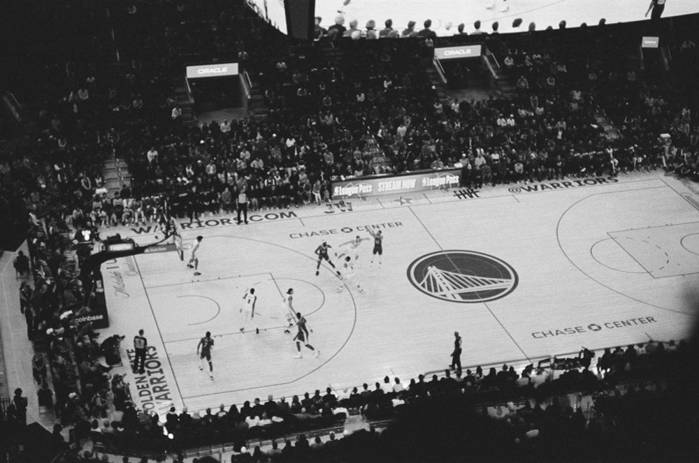 Black and white film photo of Steph Curry shooting a 3-pointer.