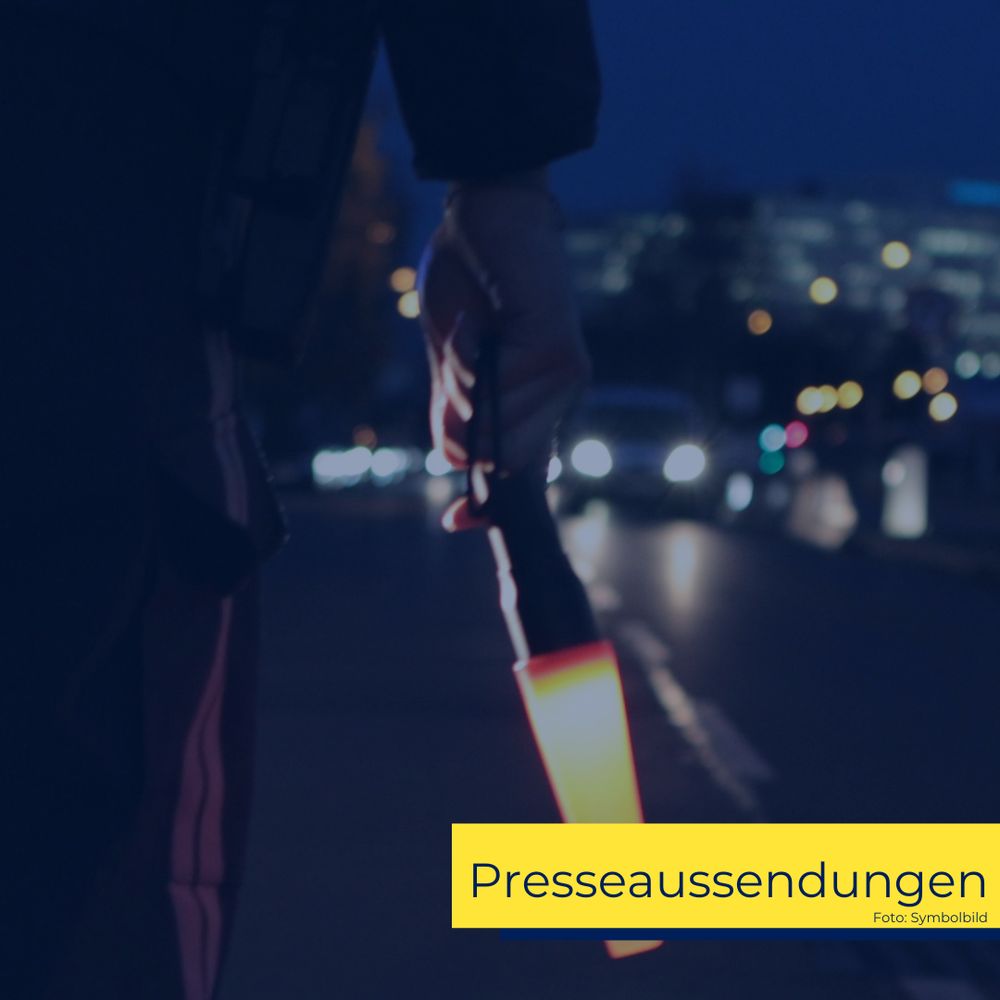 Verkehrskontrolle der Polizei, die eine Taschenlampe mit Verkehrskegel hält, um die Fahrer zum Anhalten aufzufordern.