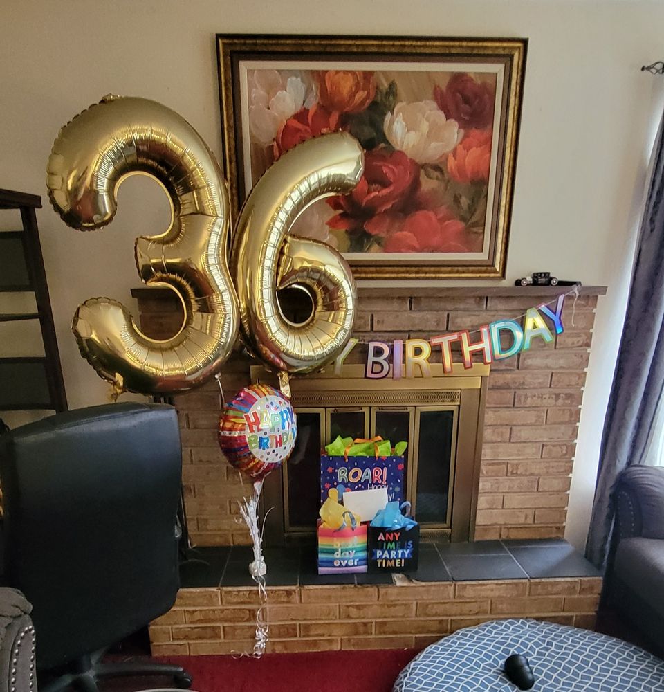 Two giant golden number 3 and 6 balloons, a "Happy Birthday" sign, a smaller "Happy Birthday" balloon, and three present bags on the mantle of my fireplace this morning.