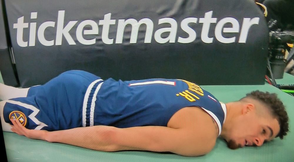 Michael Porter Jr. prostrate beneath a promo for Ticketmaster