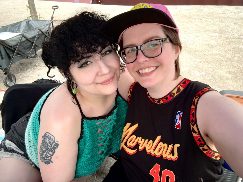 two people posing together for a selfie outside 