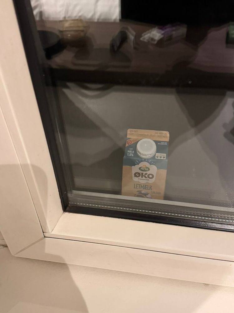 A half litre carton of milk on a hotel room windowsill