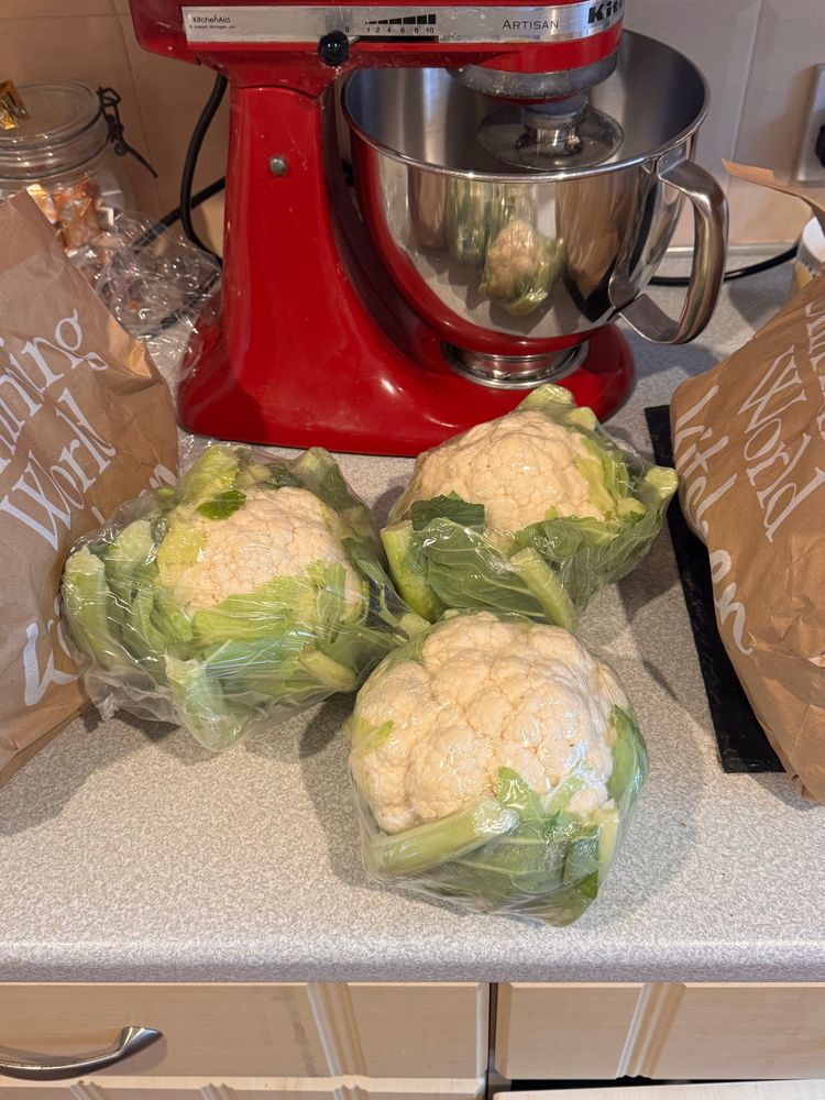 Three cauliflowers on a kitchen worktop