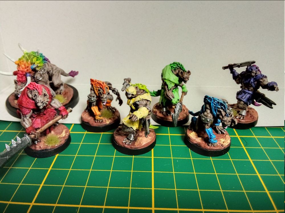 A colorful group of humanoid hyenas, arranged in rainbow colors, with a large hyena with a full rainbow mane in the background.
Minis are from Steamforged Epic Encounters: Savannah of the Gnoll 
