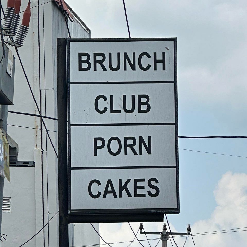 Sign advertising “Brunch Club Porn Cakes”