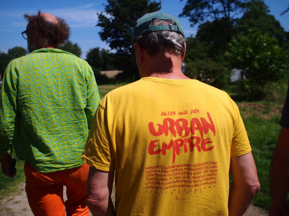 Deux hommes de dos au soleil habillés de couleurs vives.