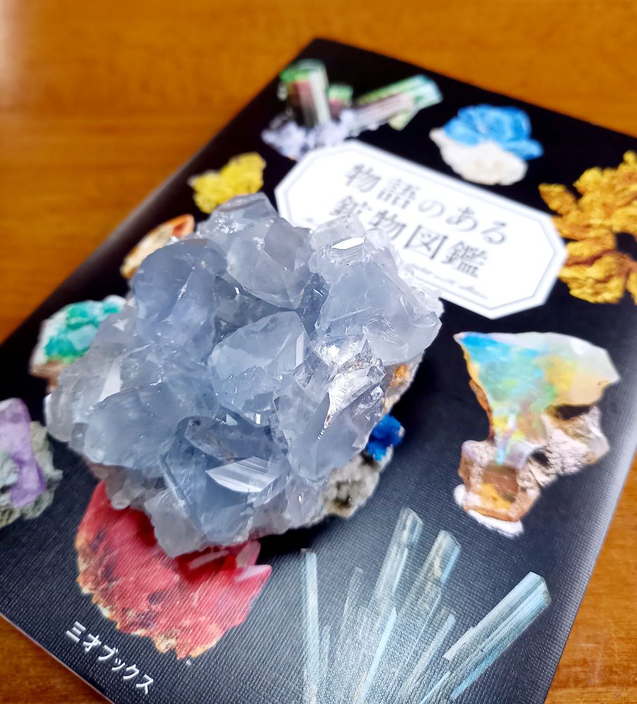 セレスタイト（天青石）の原石と『物語のある鉱物図鑑』。セレスタイトはくすんだブルーで手のひらサイズ