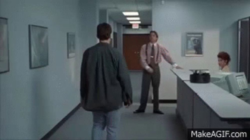 a man in a suit and tie is walking down a hallway towards a counter .