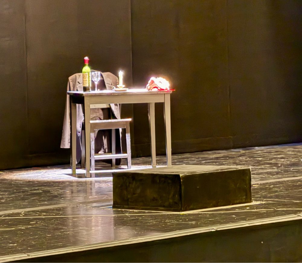 Scenery from Hoffmanns Erzählungen in düsseldorf. Writer‘s desk with candle, paper and a bottle of wine on an otherwise empty stage