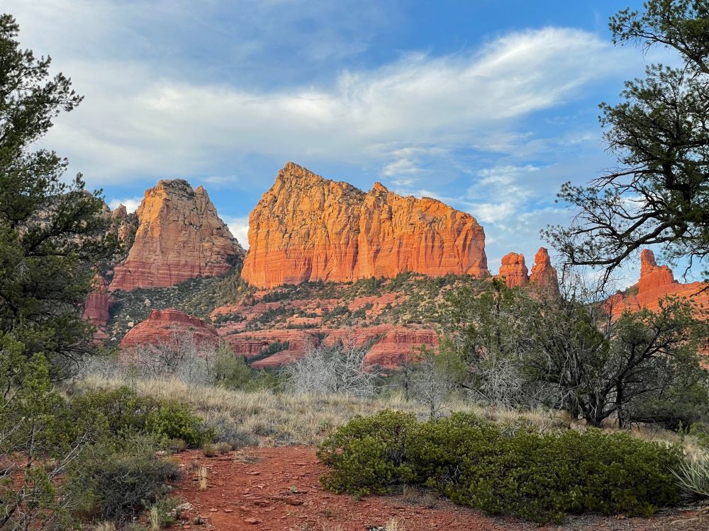 Redrock ridge in evening light, under a blue sky.