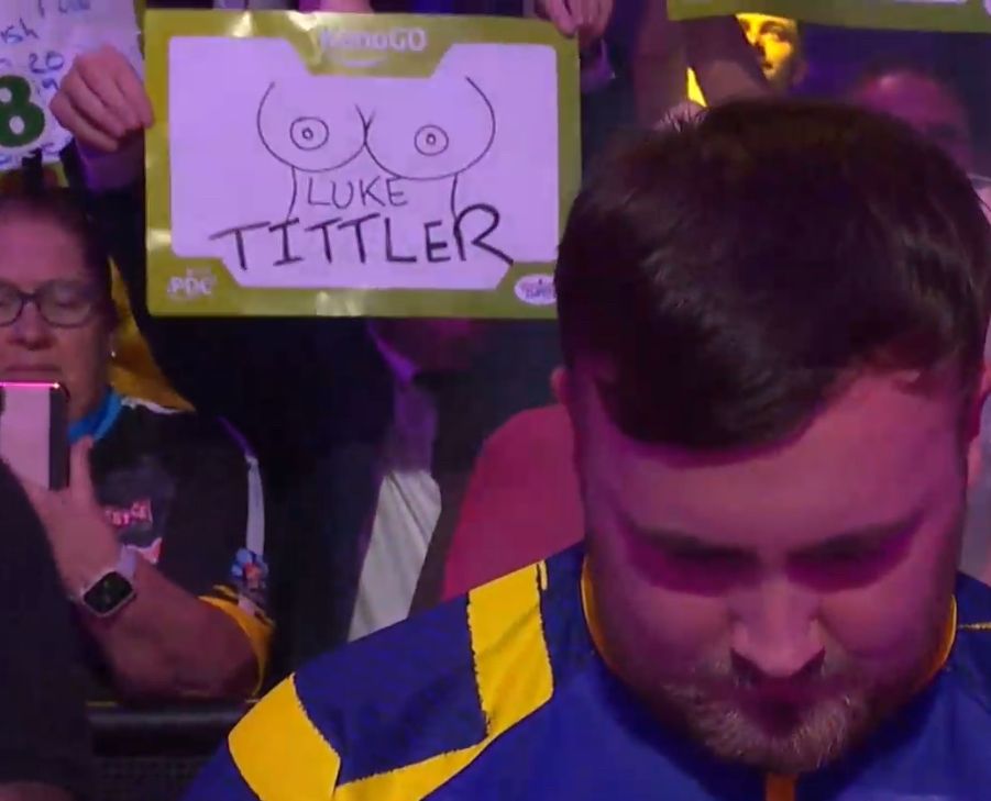 Luke Littler with a Luke Tittler sign in the background