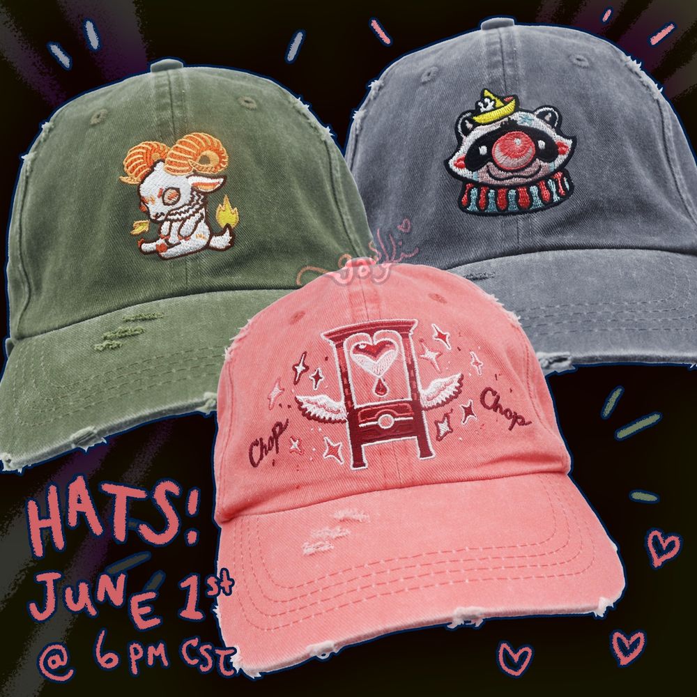 Baseball hat samples. One is a pink hat with a red/white guillotine with the words chop chop next to it. Another is a grumpy little Aries ram on a green hat. The last is a hobo clown raccoon on a grey hat. 
