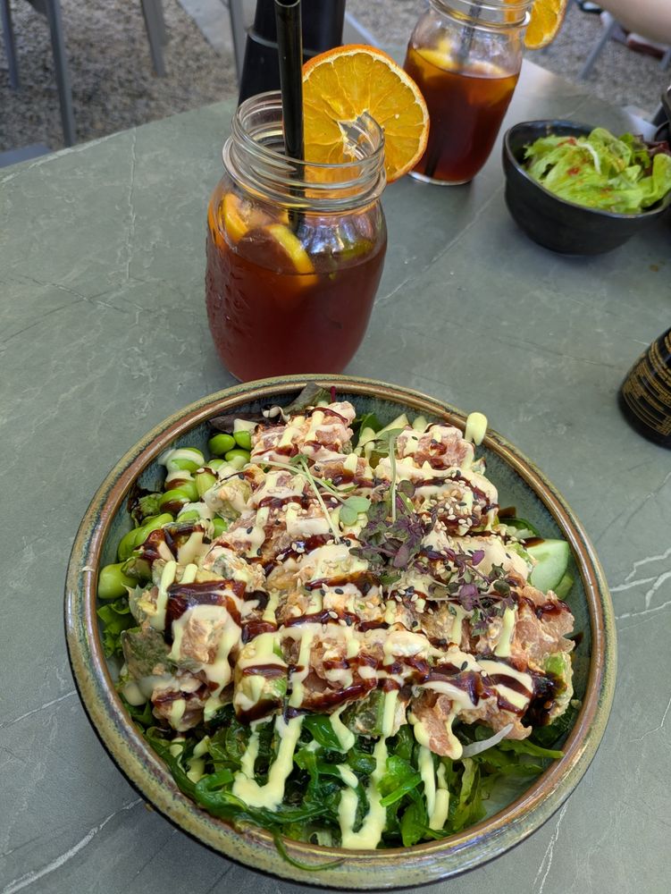 Photo of a rice bowl. You can't see the rice since it's topped with thuna, salad, Avocado and so on