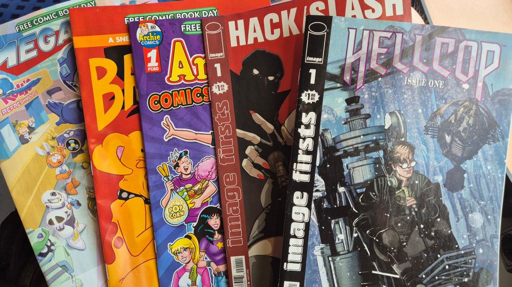 Five comic books, spread out. They are a wide age mix: Megaman, Bad Kitty, Archie, Hack/Slash and Hellcop.