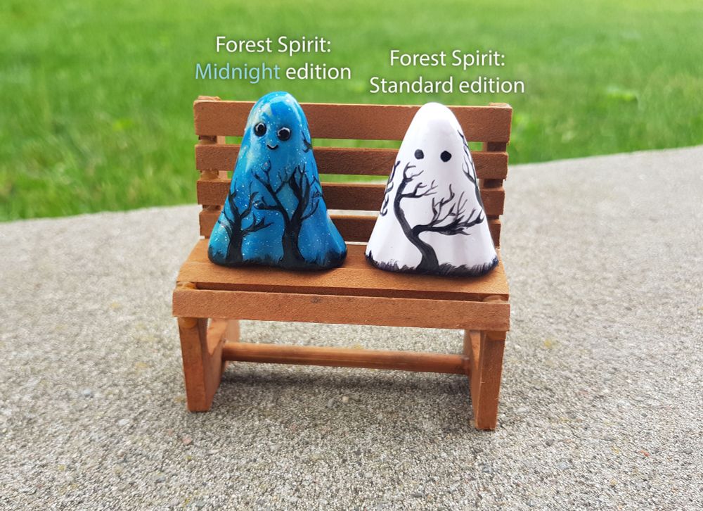 Miniature ghost figurines. One is blue the other is white. Both have trees painted on them.
