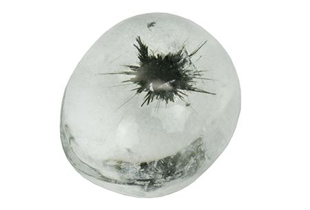 A less translucent, more white looking quartz with mannardite from Madagascar-4.85ct. This time the stone itself is a white egg, described as oval + cabochon if such terms say anything to you. But there is a crack and a widening hole on top/side of the egg-resembling stone, and again the black of mannardite is breaking out of its containment.

Just with a different looking effect given it now seems as if something was breaking out of an egg. From a gemfrance auction site, so gone already.