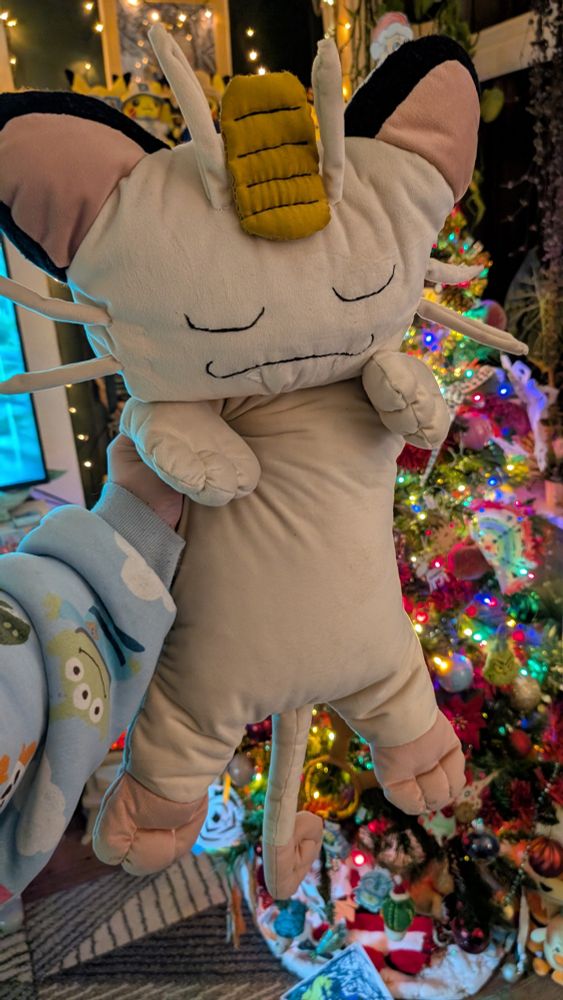 Custom shiny Meowth plush in front of my Christmas tree 🎄