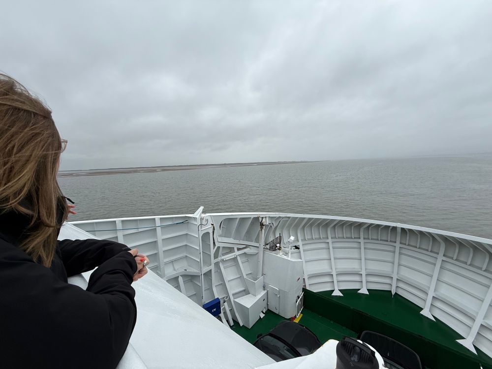 Auf dem Sonnendeck der „Sylt Express“ (Fähre zwischen List auf Sylt und Havneby auf der dänischen Insel Rømø).
Blick Richtung Bug, Rømø ist schon zu sehen. Links am Bildrand steht eine Frau und schaut in Richtung Land.
