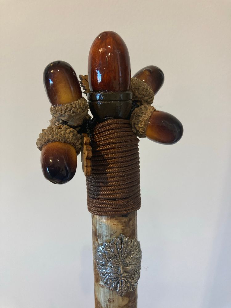 The handle of a walking stick with acorns and oak leaves 