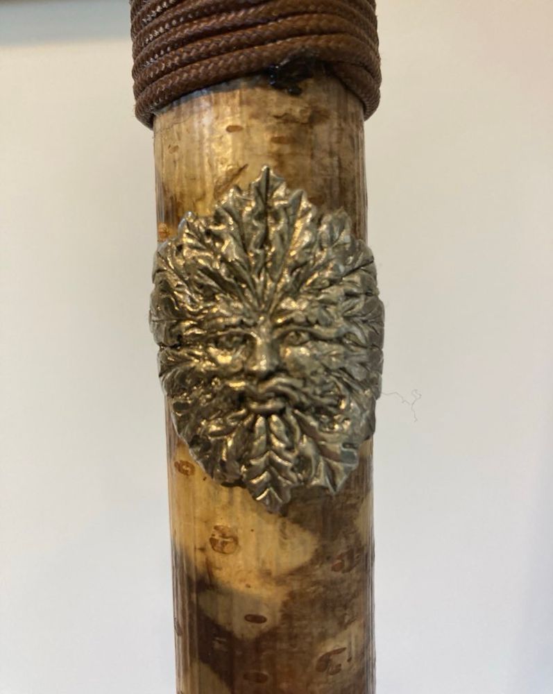 A Green Man decorative on the walking stick
