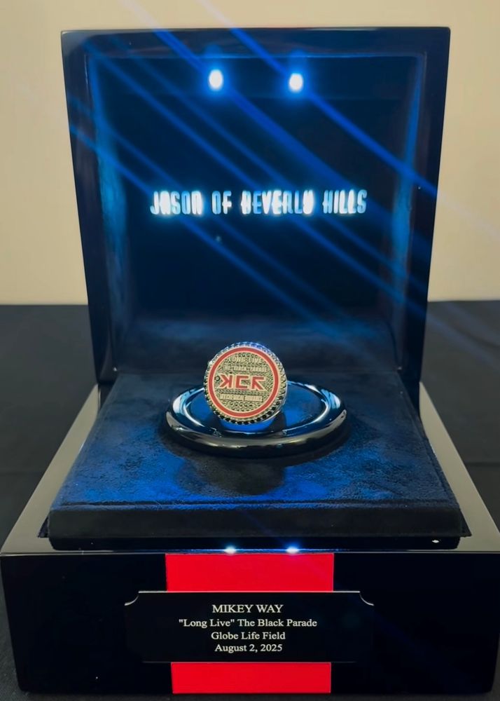 Custom silver “championship ring” designed for Mikey Way by Jason of Beverly Hills. The ring is features black diamonds, a red enamel design that reads “MCR” in Kaposhka, and silver lettering that says, “Long Live the Black Parade - My Chemical Romance” on the center of the ring. The ring is housed in a black box with a plaque which reads, “MIKEY WAY “Long Live” The Black Parade, Globe Life Field, August 2, 2025.” 