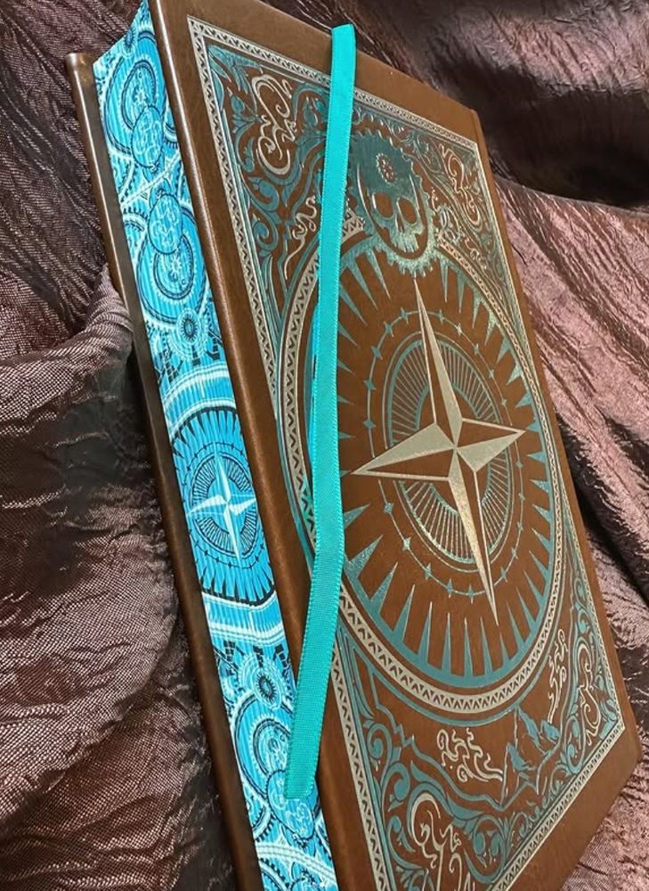 Special edition of "Echoes of the Imperium" with brown faux-leather hardcover, teal and silver foil, and teal ribbon bookmark, displaying the compass rose sprayed edges.