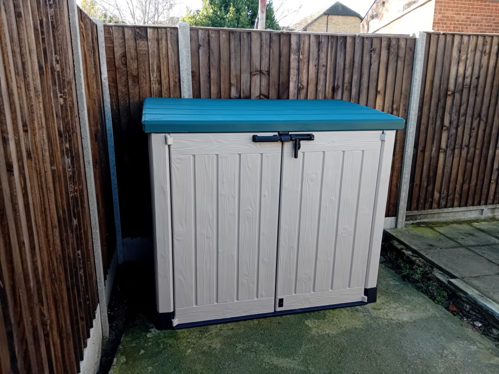 Green and white storage box in the garden, proudly self-assembled by fiancée and me