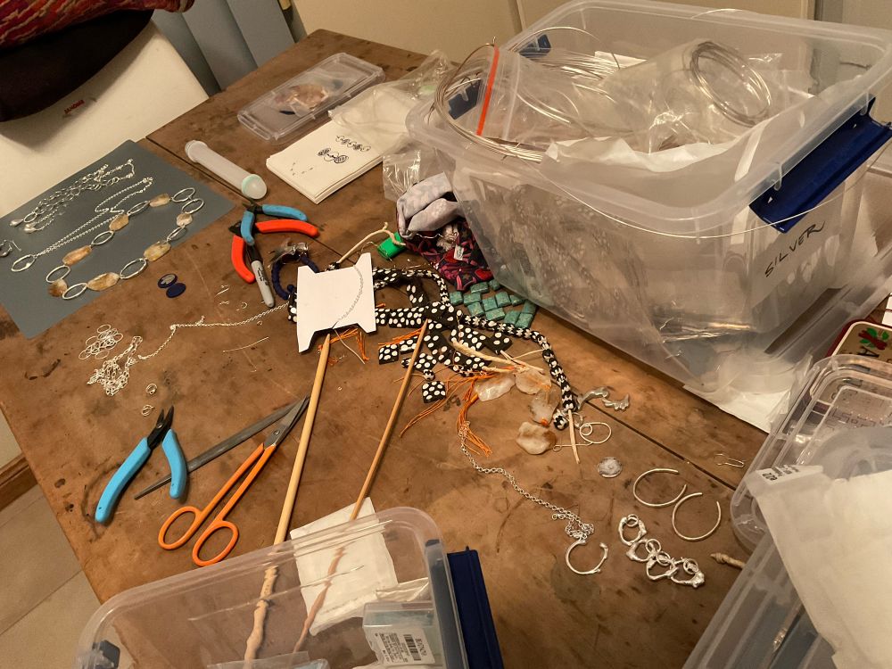 Messy jewellery bench with tools beads sundry silver rings