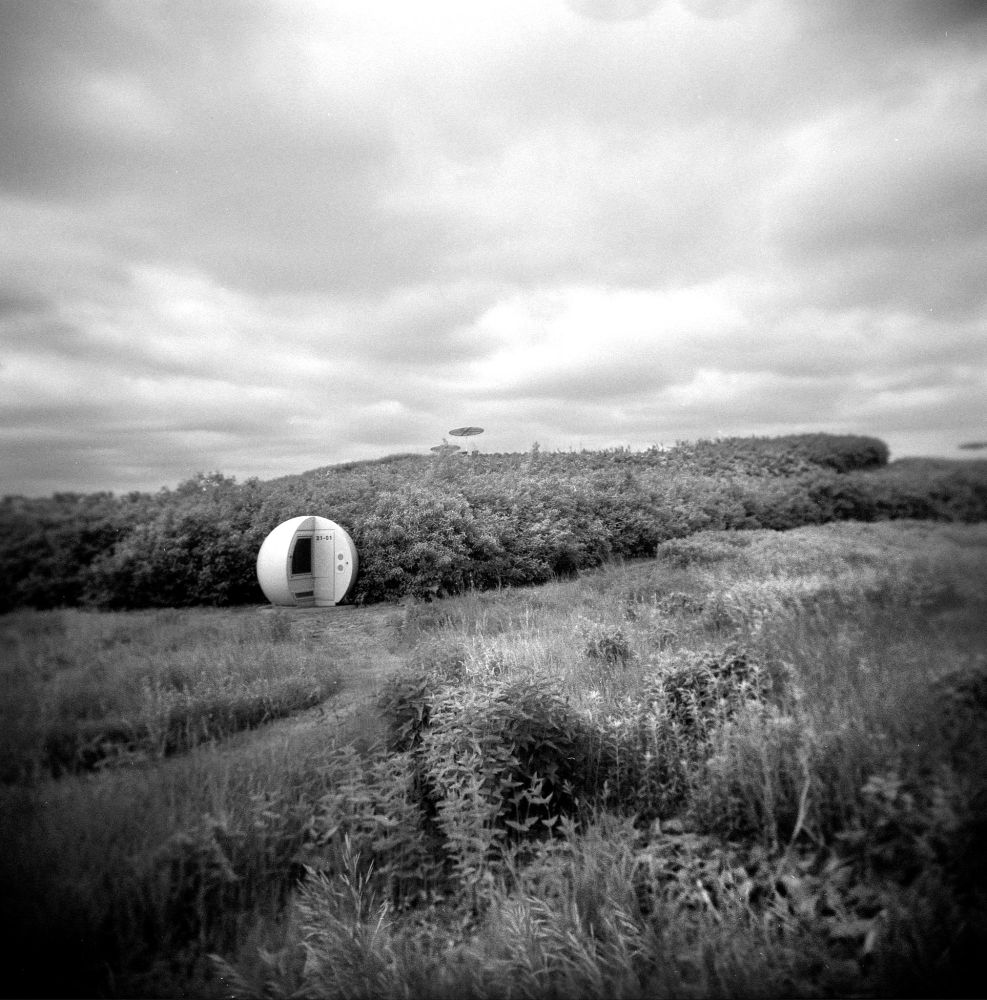 An alien-looking landfill methane capture pod stands in a field at Parc Frédéric-Back in northern Montréal, with ominous clouds in the background.