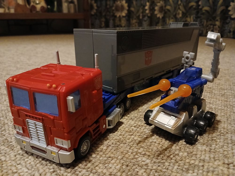Optimus in truck mode with the trailer creature driving alongside 