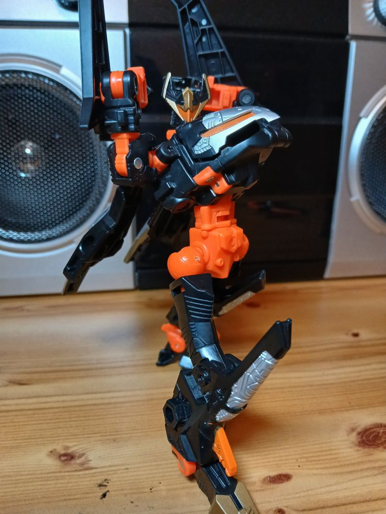 Sideways in an arms up leaning back kinda pose where his body is bending upwards 