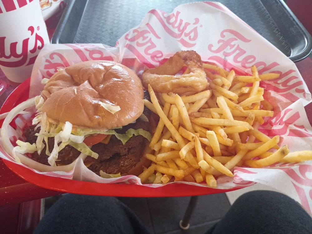 A steak burger, French fries, and an onion ring from Freddy's