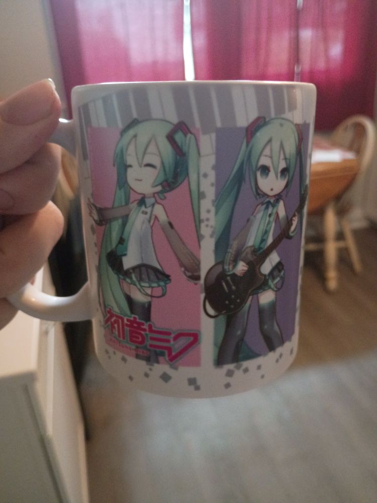 A mug with 2 pictures of Hatsune Miku on it