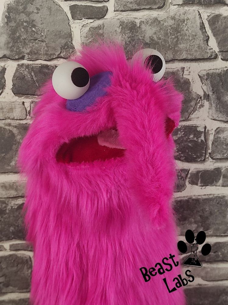 Right side head shot of the hot-pink akward worm puppet.