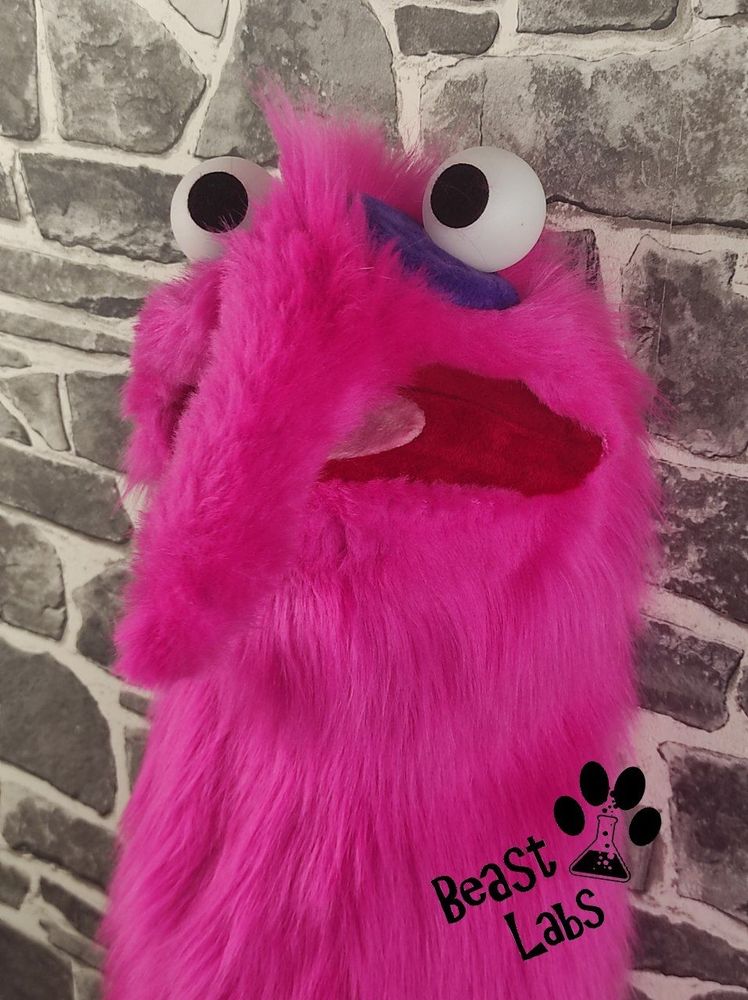 Left side head shot of the hot-pink akward worm puppet.