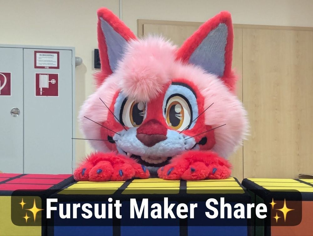 Photograph of Newton, a red, pink and blue cartoon cat fursuit with a text that says the following:

Fursuit Maker Share 