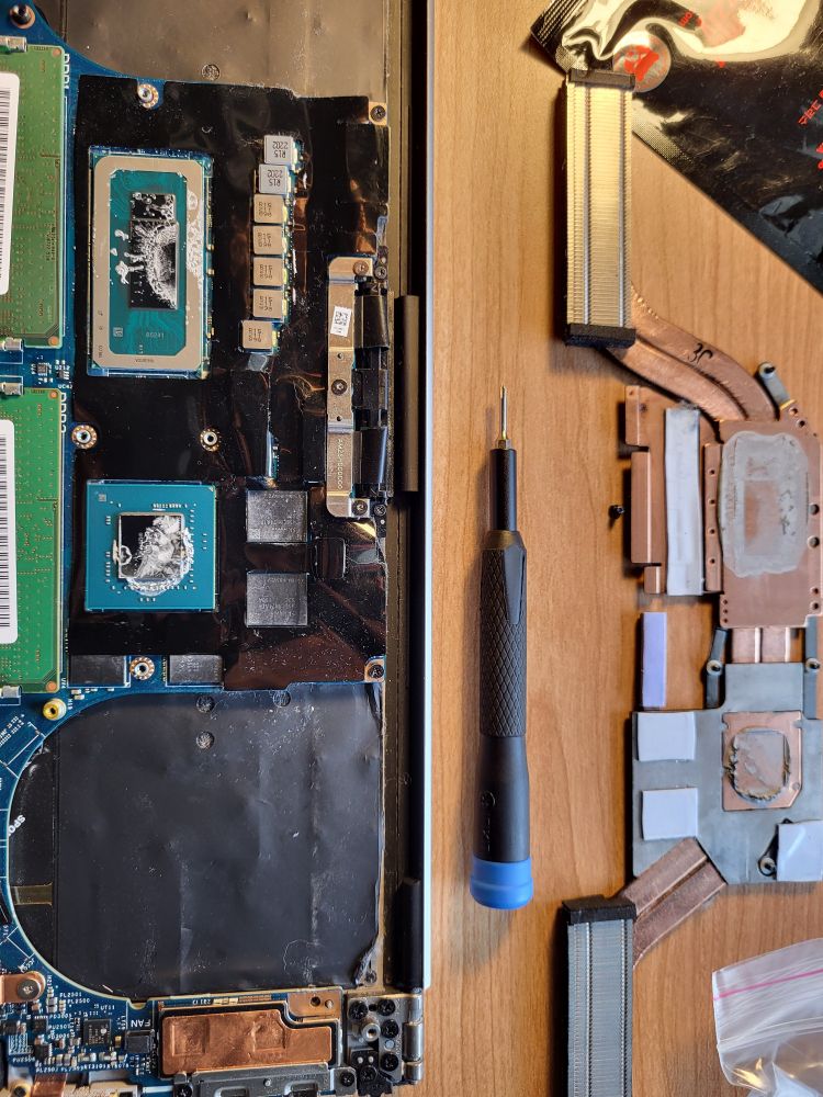 A photo of the CPU and GPU of a laptop with the heatsink removed. There's hardly any paste on the chips while it's caked onto the heatsink.