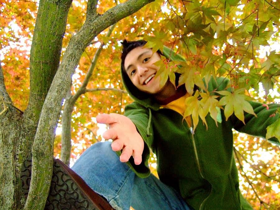 Older photo of user from college. He is above, in a tree, offering to help you up to a sturdy branch. 