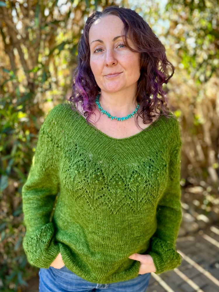 A woman wearing a loose, fuzzy, green sweater