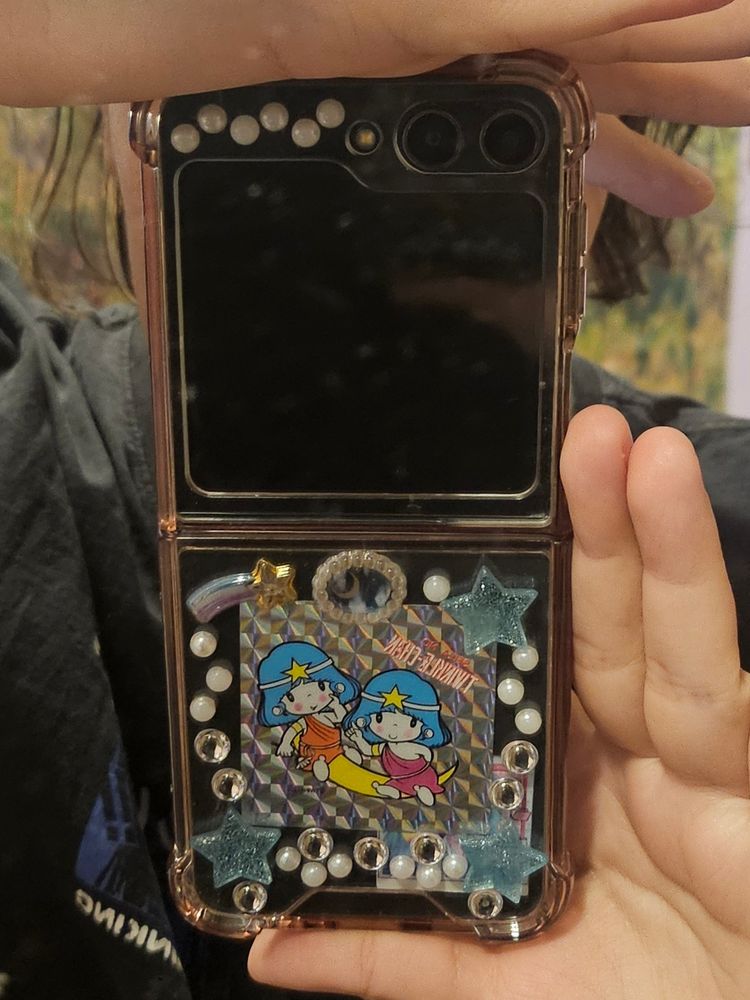 capinha transparente customizada de samsung flip 5 com pontinhos brancos e estrelas em alto relevo e um adesivo maior de "seiza no twinkle chan" no meio